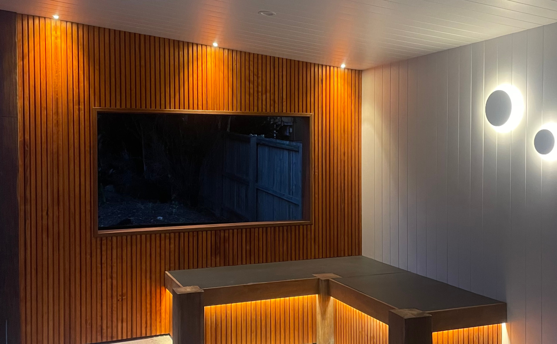 Hardwood batten wall and daybed lit at night