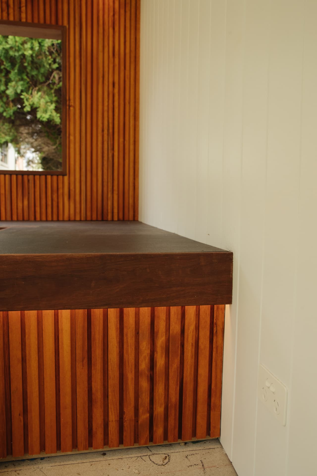 Hardwood bench end detail with batten cladding and a solid timber edge
